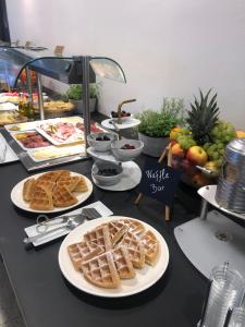 a buffet with waffles and other food on a table at Aparthotel Milenij in Baška Voda