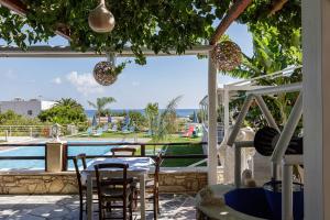 un patio con mesa, sillas y piscina en Gorgona Hotel en Balíon