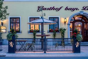 een café met een paraplu voor een gebouw bij Hotel Bayrischer Löwe in Osterhofen