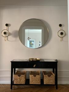 a mirror on a wall above a table with baskets at Dragonfly Residence in Belgrade