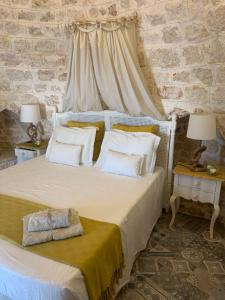 a bedroom with a large bed with white pillows at TRULLI TESORO in Cisternino