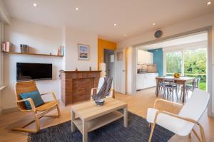 sala de estar con mesa y sillas en Appartement La Rafale - accès privé plage - jardin - arrivée autonome, en Gravelines