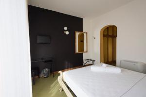 a bedroom with a white bed and a black wall at Mami Sabaudia Hotel in Sabaudia