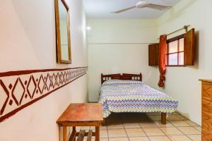 a bedroom with a bed and a wooden table at Hotel Posada Playa Manzanillo in Puerto Escondido