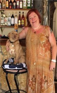 a woman standing next to a dog sitting on a stool at Poseidon Hotel in Kassiopi