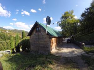 a small wooden building with a green roof at Medeni sat Mecavnik in Mokra Gora