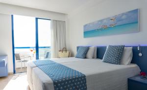 a bedroom with a large bed with blue accents at Anonymous Beach Hotel (Adults 16+) in Ayia Napa