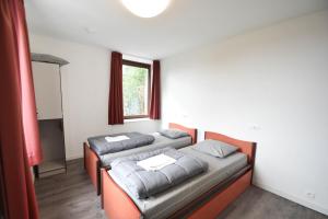 two beds in a room with a window at Auberge de Jeunesse de La Roche - Champlon in Tenneville +16 photos
