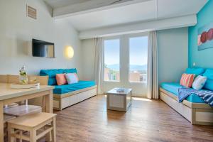 a living room with blue furniture and a large window at Résidence Pierre & Vacances Les Parcs de Grimaud in Grimaud