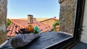 a window with a view of a roof at Casa Catraia Gondramaz no Pulmão da Serra da Lousã in Gondramaz