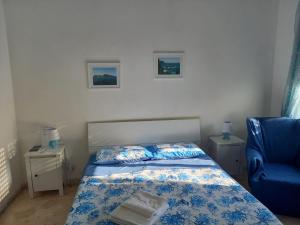 a bedroom with a bed and a blue chair at A Casa di Lidia B&B Gaeta in Gaeta