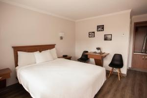 a hotel room with a white bed and a desk at Motel Newstar Laval in Laval