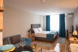um quarto de hotel com uma cama e uma sala de estar em Magellan Family Lux Apartments Novi Sad em Novi Sad