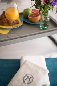 a table with a plate of food and a glass of orange juice at Magellan Family Lux Apartments Novi Sad in Novi Sad