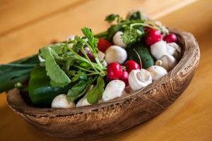 a wooden bowl filled with vegetables on a table at Apartmány Pinus, Tále, Chopok Juh in Tale