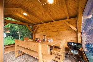 eine Holzhütte mit einem Tisch und Stühlen in der Unterkunft Apartmány Pinus, Tále, Chopok Juh in Tale