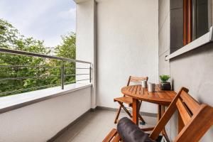 a small balcony with a wooden table and chairs at Apartamenty Solny Brzeg by Renters Prestige in Kołobrzeg