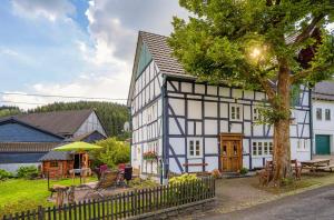 an old white and black building with a patio at Ortmanns Eulennest in Finnentrop