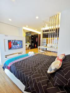 a bedroom with a large bed with a flat screen tv at Simfoni Balakong Internet & Netflix Designer Studio in Kampong Baharu Balakong