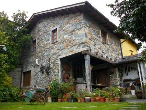 una vieja casa de piedra con flores en un patio en Casa de Aldea Rural Los Glayus, en Luarca