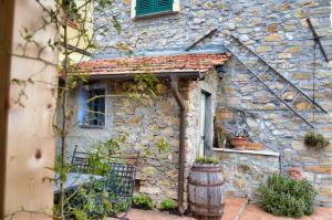 una casa de piedra con una ventana y un barril en Agriturismo Da Ciletta, en San Bartolomeo al Mare