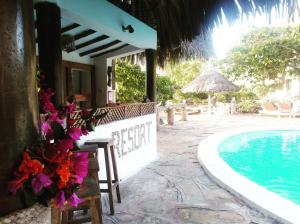 a resort with a pool and a table and chairs at Flamingo Villas Resort in Malindi