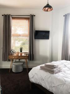 um quarto com uma cama, uma secretária e uma janela em Newly refurbished apartment in Chapel Allerton, Leeds em Moortown