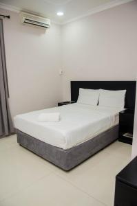 uma cama num quarto com piso branco em Residencial Horizonte 2 em Maputo
