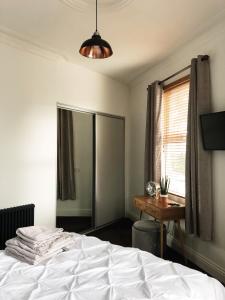 a bedroom with a bed and a desk and a window at Stylish 1-Bedroom Apartment in Chapel Allerton with Free Parking in Moortown