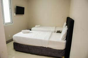 two beds in a small room with white sheets at Residencial Horizonte 2 in Maputo