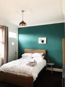 a bedroom with a green wall and a bed at Newly refurbished apartment in Chapel Allerton, Leeds in Moortown