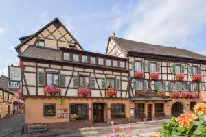 a building with flower boxes on the front of it at Hôtel A la Vignette - COLMAR-NORD in Saint-Hippolyte