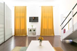a living room with yellow curtains and a vase of flowers at Top Apartment nahe Zentrum in Vienna
