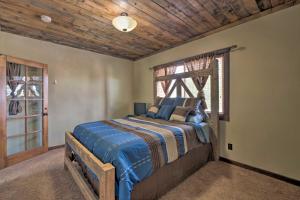 a bedroom with a bed with a wooden headboard and a window at Well-Appointed Sterling Casita with Full Kitchen! in Sterling