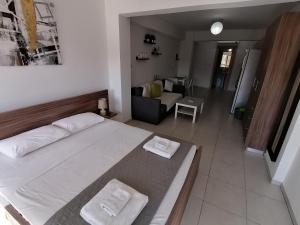 a bedroom with a large bed and a living room at Must Stay - City Center in Larnaca