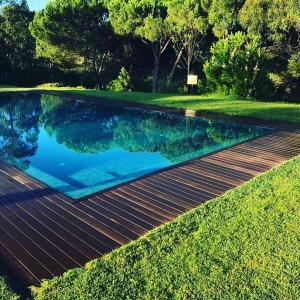 a swimming pool with blue water in a yard at Casal do Frade in Sesimbra