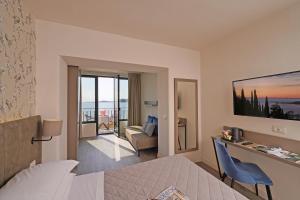 a hotel room with a bed, table and a television at Hotel Du Lac in Gardone Riviera