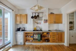 a kitchen with wooden cabinets and a stove top oven at Pass the Keys - Beautiful stylish flat in South West London in London