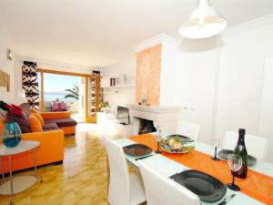 een woonkamer met een tafel en stoelen en een bank bij Apartment Vida Sana with Sea Views and Garden in Port d'Alcudia