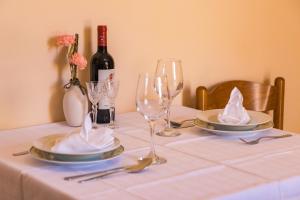 a table with two plates and glasses and a bottle of wine at Apartments Kenđel in Fažana