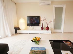 una sala de estar con TV y un plato de fruta en una mesa. en Apartment Corales de Mar, at Alcudia Beach, en Alcudia