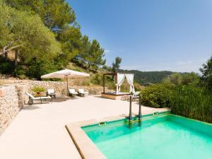 uma piscina com uma mesa e um guarda-sol em Villa Finca Garrafa para 6 con piscina en Port d'Andratx em Andraitx