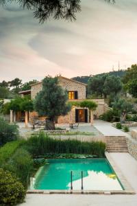 uma vista exterior de uma casa de pedra com uma piscina em Villa Finca Garrafa para 6 con piscina en Port d'Andratx em Andraitx