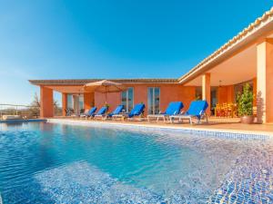 una piscina con sillas azules y una casa en Villa Son Bordils Petit, en Inca