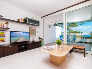un soggiorno con grande TV e tavolo di Apartment Oiza Canopus Sea Views at the beach a Alcudia