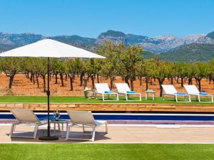 a group of chairs and an umbrella next to a pool at Villa Es Velar 34 de Binissalem in Binissalem