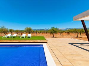 a swimming pool with chairs and a view of a field at Villa Es Velar 34 de Binissalem in Binissalem