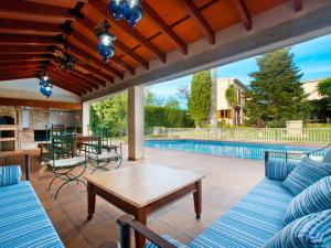 a patio with a table and chairs and a pool at Villa Tramontana de Lloseta, piscina y vista montaña in Lloseta