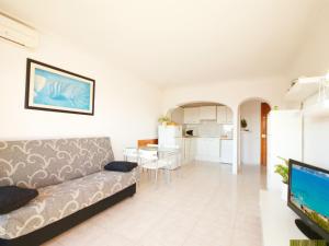 a living room with a couch and a kitchen at Apartamento Arcoiris, con piscina y junto a playa de Alcudia in Alcudia +24 photos