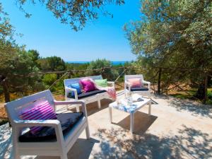 3 sillas y una mesa en un patio en Villa Sa Rota, con piscina y vista mar, en Alcudia